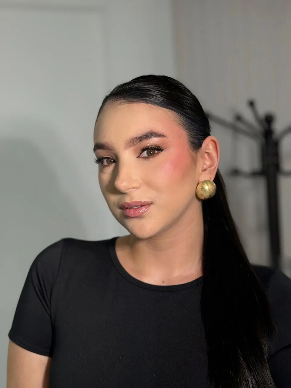 Mujer en primer plano con fondo claro, posando un maquillaje social hecho por una maquilladora profesional manizales