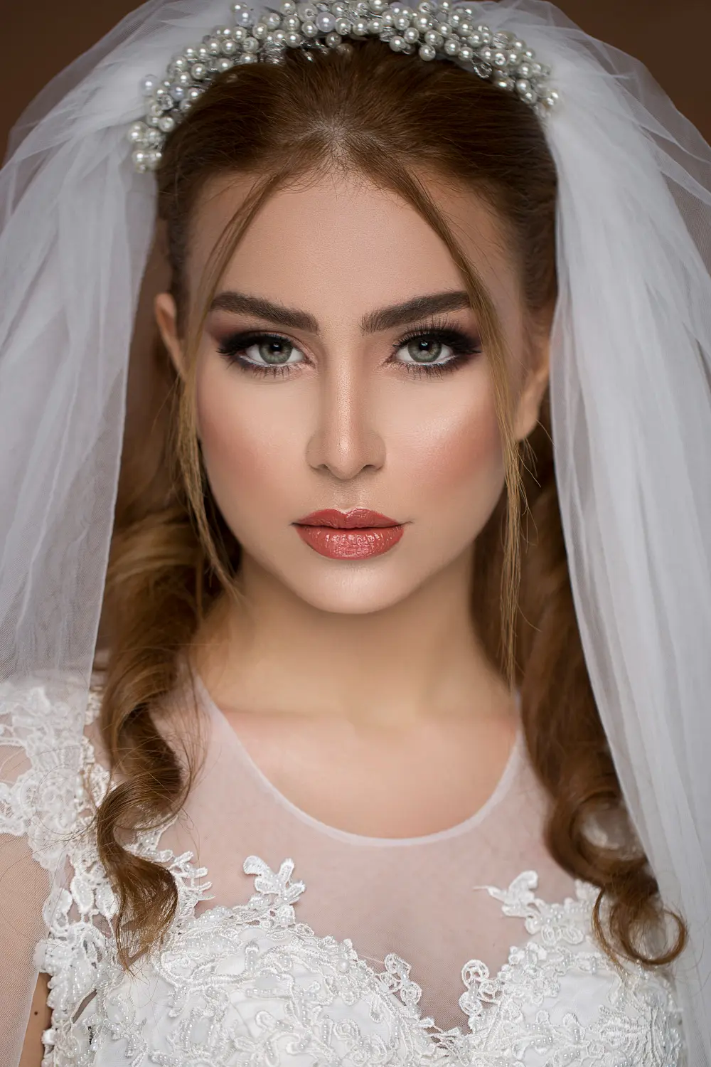 Mujer de frente con vestido y velo de novia y posando un maquillaje para novias en manizales