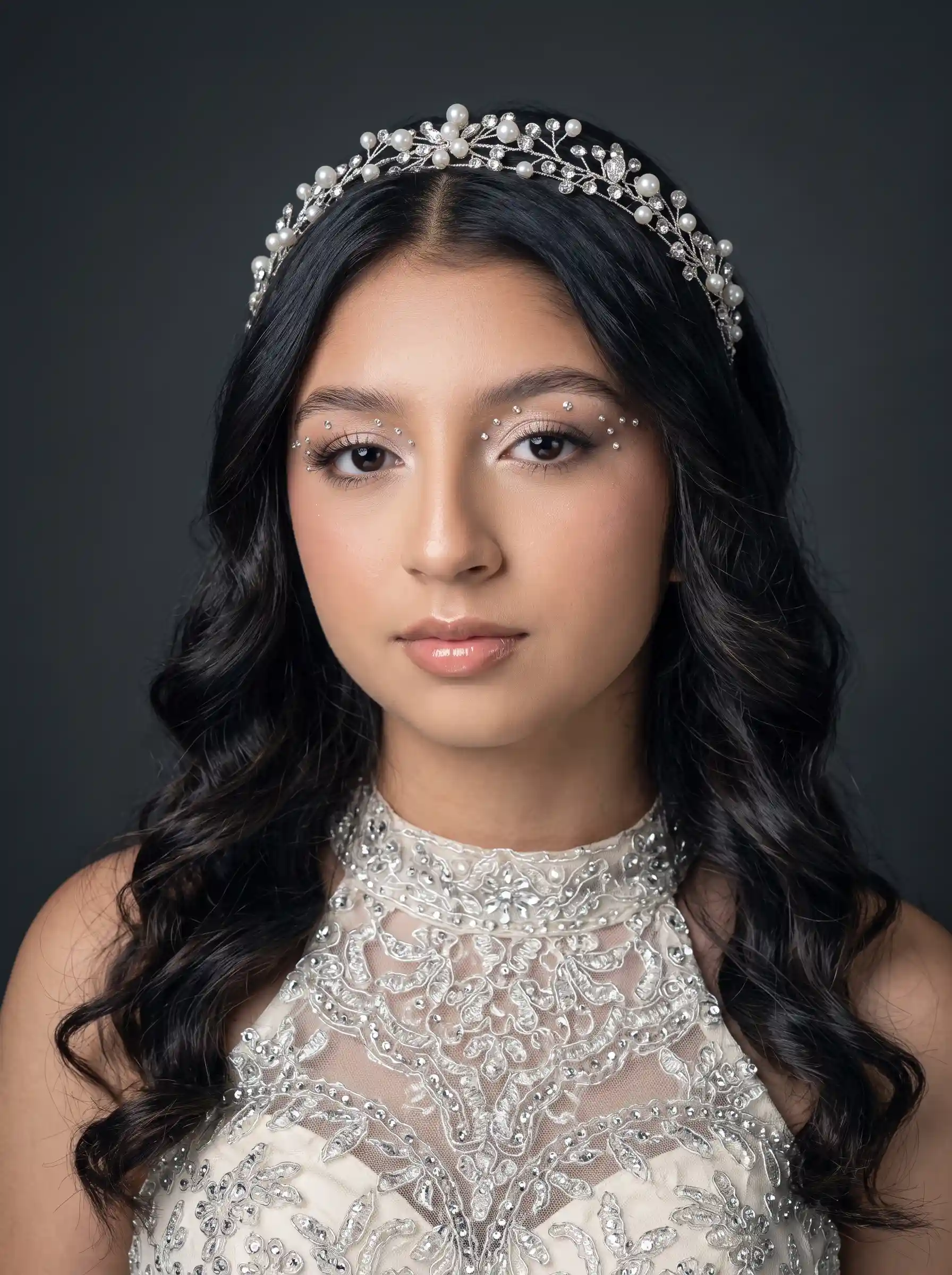Mujer en sus quince años posando maquillaje para quinceañeras en manizales, hecho por maquela, con vestido brillante. 